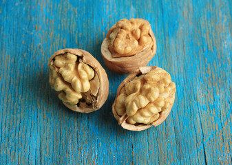 Broken walnuts on wooden table close-up