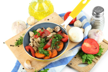 Sliced fresh vegetables in pan on wooden board isolated on
