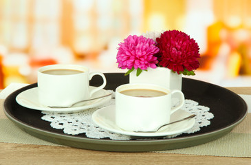 Cups of coffee on tray on table in cafe