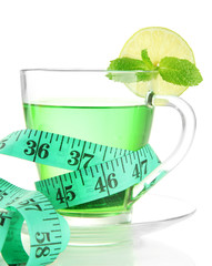 Transparent cup of green tea and measuring tape isolated