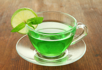 Transparent cup of green tea with lime and mint