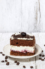 Chocolate and cherry cake. Coffee beans around, wooden backgroun