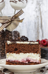 Chocolate and cherry cake. Coffee beans around, wooden backgroun