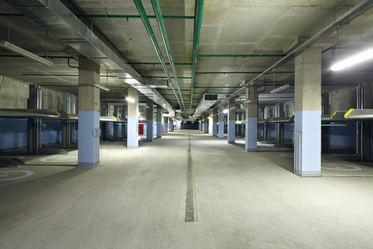 Large indoor two-level parking with electrolifts for many cars.