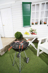 Barbecue with sausages, table with fruits and flowers