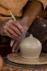 Potier réalisant une poterie en terre sur son tour.
