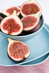 Ripe figs lying on a blue plate on a pink napkin