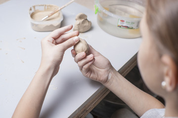 Girl make toyfrom clay