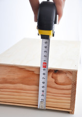 measuring a wooden box with a roulette