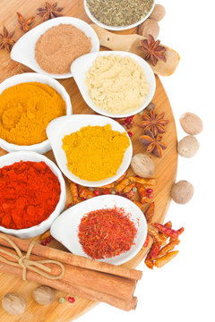 colorful plates of  spices on wooden board
