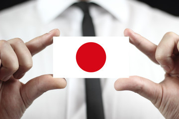 Businessman holding a business card with a Japan Flag