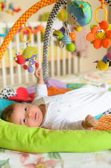 Obraz na płótnie Canvas Baby boy with hanging toys