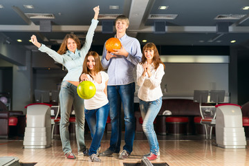 Group of young friends playing bowling