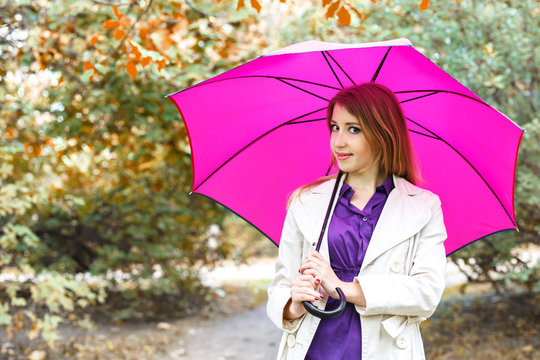 Girl with umbrella at autumn park
