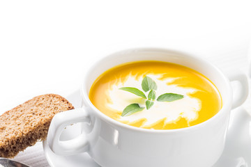 Pumpkin soup with basil on served table