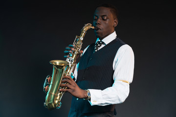 Fototapeta na wymiar Retro african american jazz musician playing on his saxophone. W