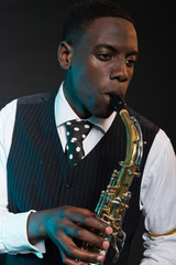 Naklejka premium Retro african american jazz musician playing on his saxophone. W