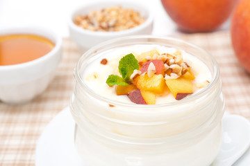 homemade yogurt with honey, peaches and nuts, close-up