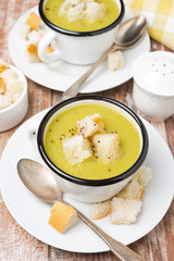 spicy zucchini soup with croutons in a cup, top view