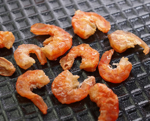 Dry small shrimps on black foam plate