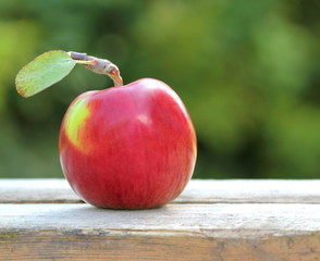 Red, fresh and organic apple on old table