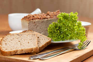 Venison pate on a plate decorated with salad.