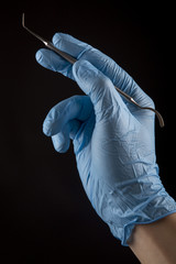 Hand with a Dental Instrument -