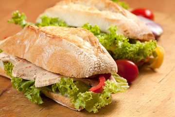 Tasty sandwiches with vegetables on a wooden table.