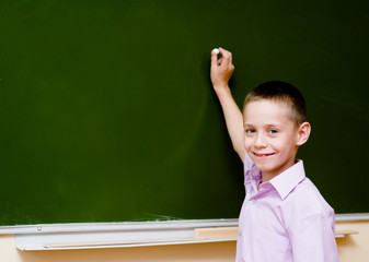 schoolboy holding a white chalk about to write