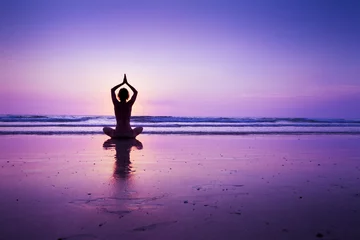 Poster Vrouw die yoga beoefent op het strand © NicoElNino