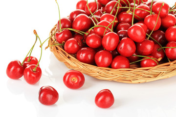 Cherry berries in wicker basket isolated on white