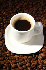 Cup of coffee on coffee beans background