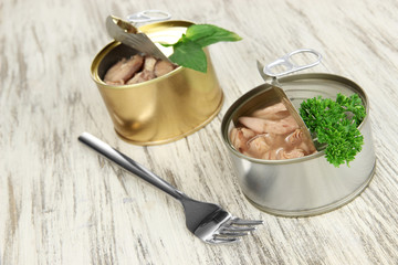 Open tin cans, on wooden background