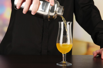 Bartender making cocktail on bright background, close-up