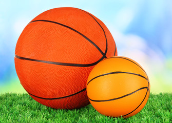 Basket balls, on green grass, on bright background