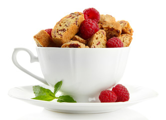 Tasty cookies with raspberries in cup isolated on white