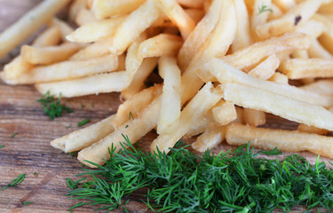 French fries on wooden board close-up