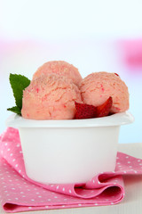 Tasty ice cream scoops in bowl, on table