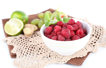 Raspberries in small bowl on napkin isolated on white
