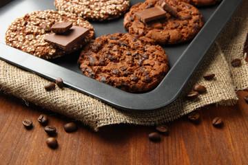 Homemade cookies on dripping pan, on wooden background