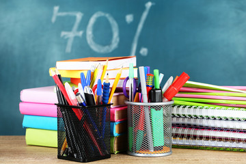 Office supplies on table on school board background