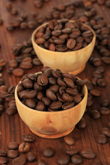 Coffee beans in bowls on wooden background