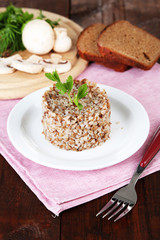 Buckwheat in plate with bread and vegetables closeup