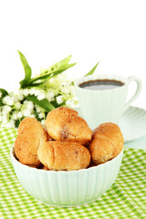 Tasty croissants and cup of coffee on table on white background