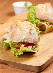 Tasty sandwiches with vegetables on a wooden table.