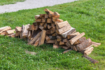 Pile of firewood on green grass background