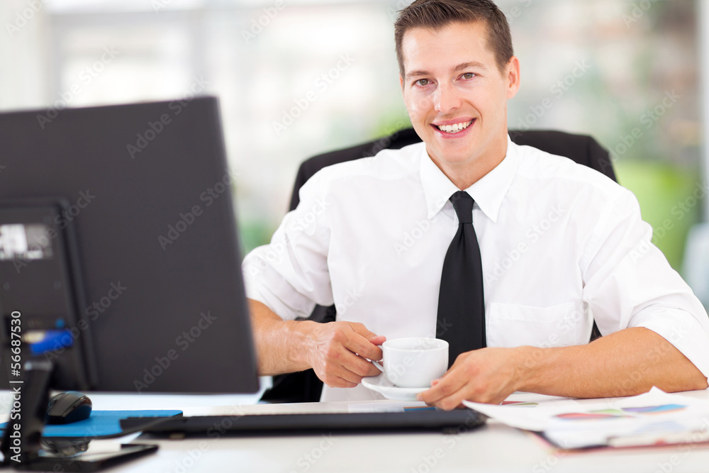 Wall mural young office worker drinking coffee