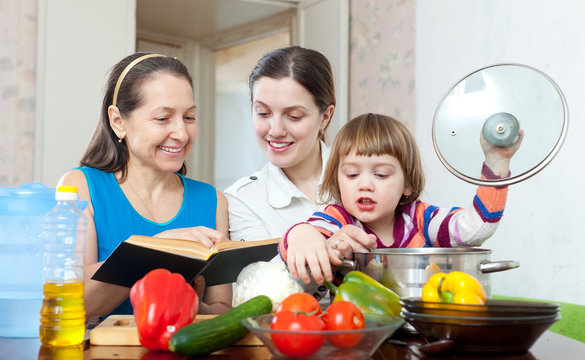 Happy women  cook vegetables in  kitchen