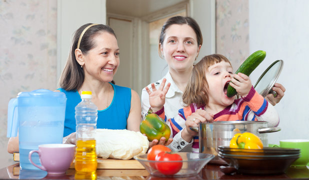 Two  women with baby girl with vegetables