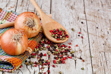 fresh onions and peppercorns in a spoon